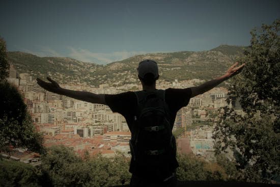 Eurail customer testimonials | Male with a town view with his arms open during the day