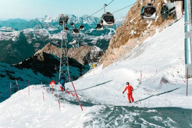TOP 5 Europe Winter Destinations | Skiing people and moving cable cars above them in Kitzsteinhorn, Austria